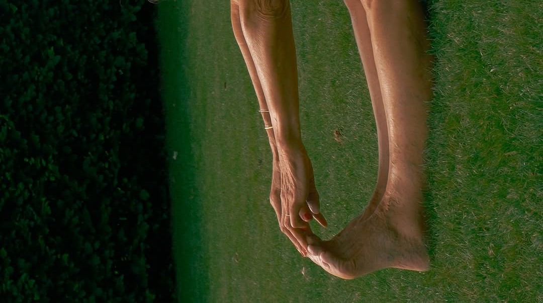 A woman moving gently on grass at golden hour
